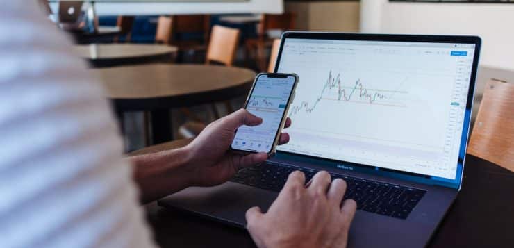 person using smartphone and MacBook Pro